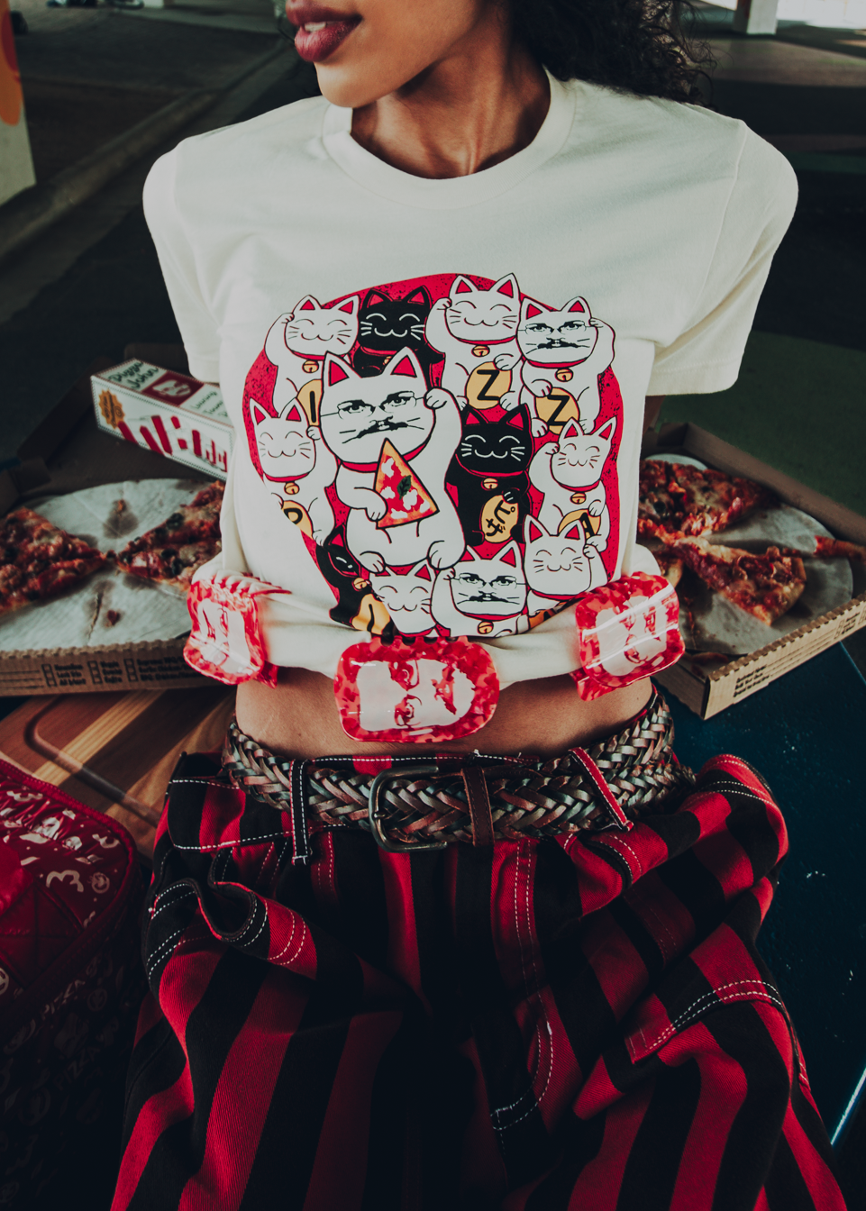 Person wearing a white t-shirt with cat graphics and with hair claws clipped to the bottom of the shirt.