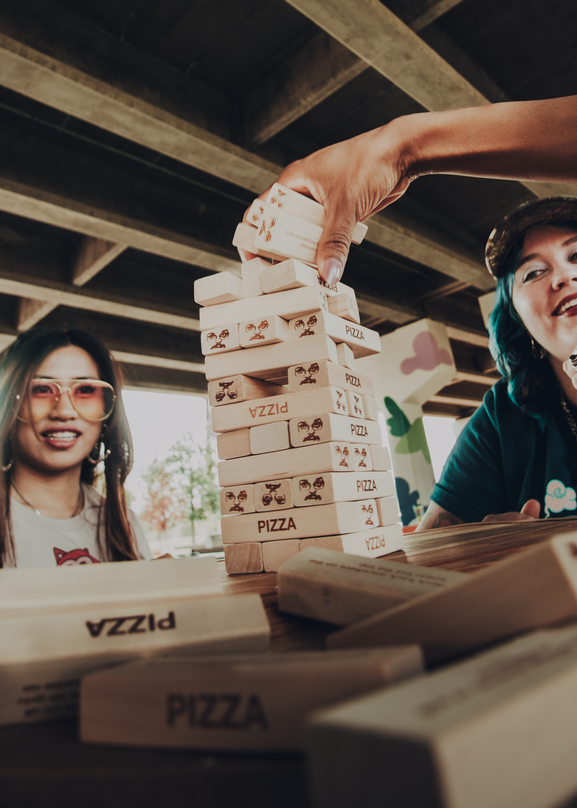 People playing a pizzamas tumbling block game