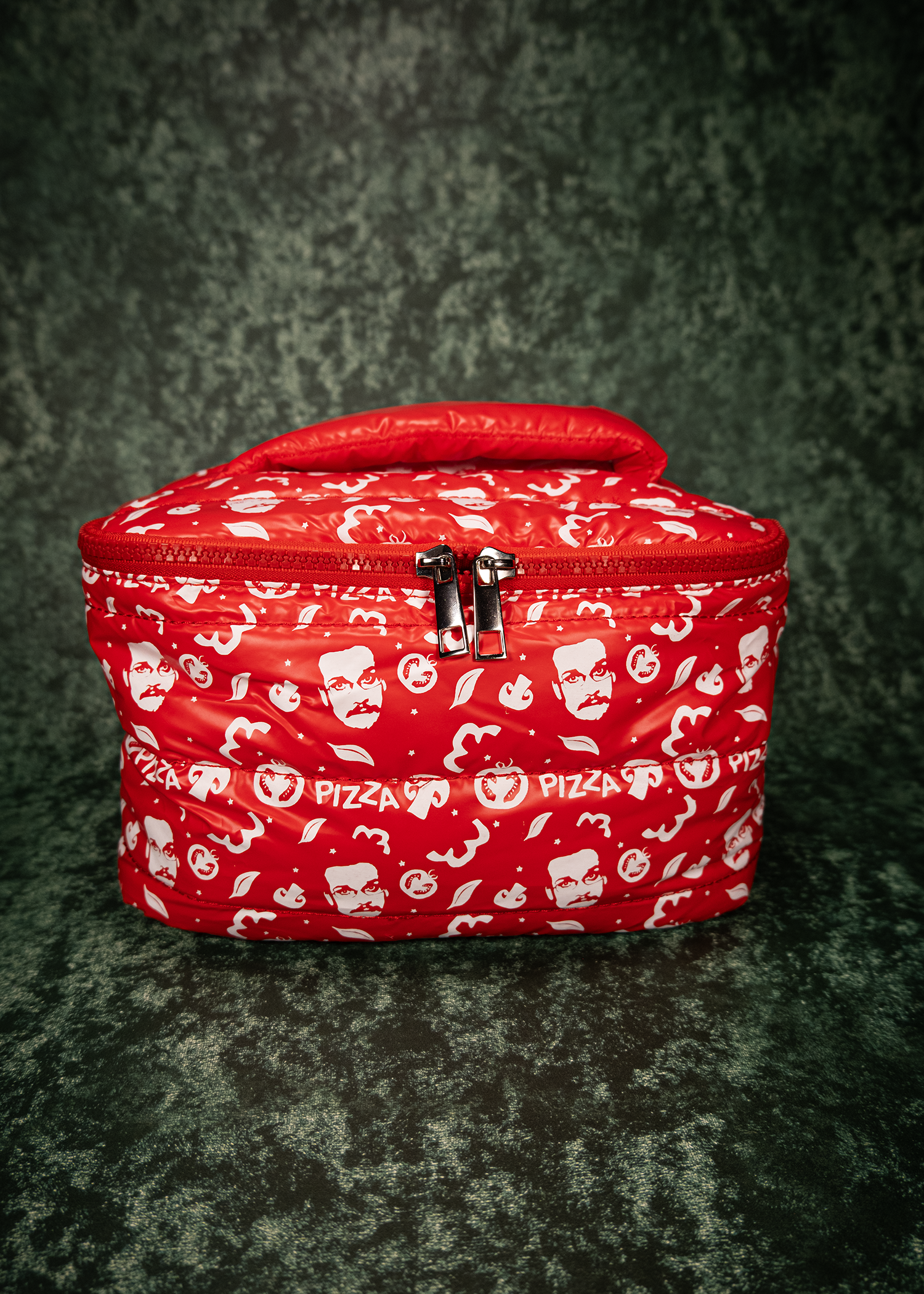Red puffy bag with pizza-themed design on a dark textured background