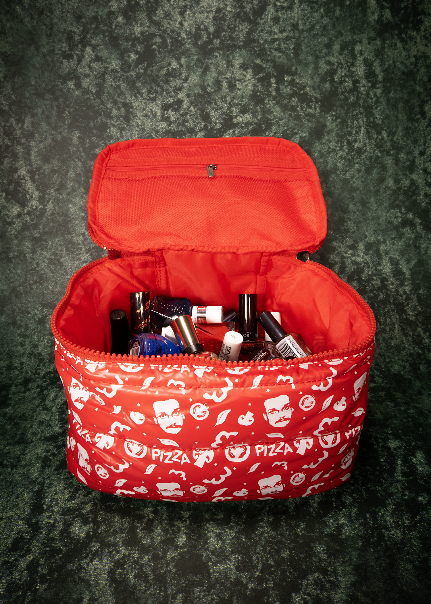 Red puffy bag with pizza-themed pattern on a textured surface