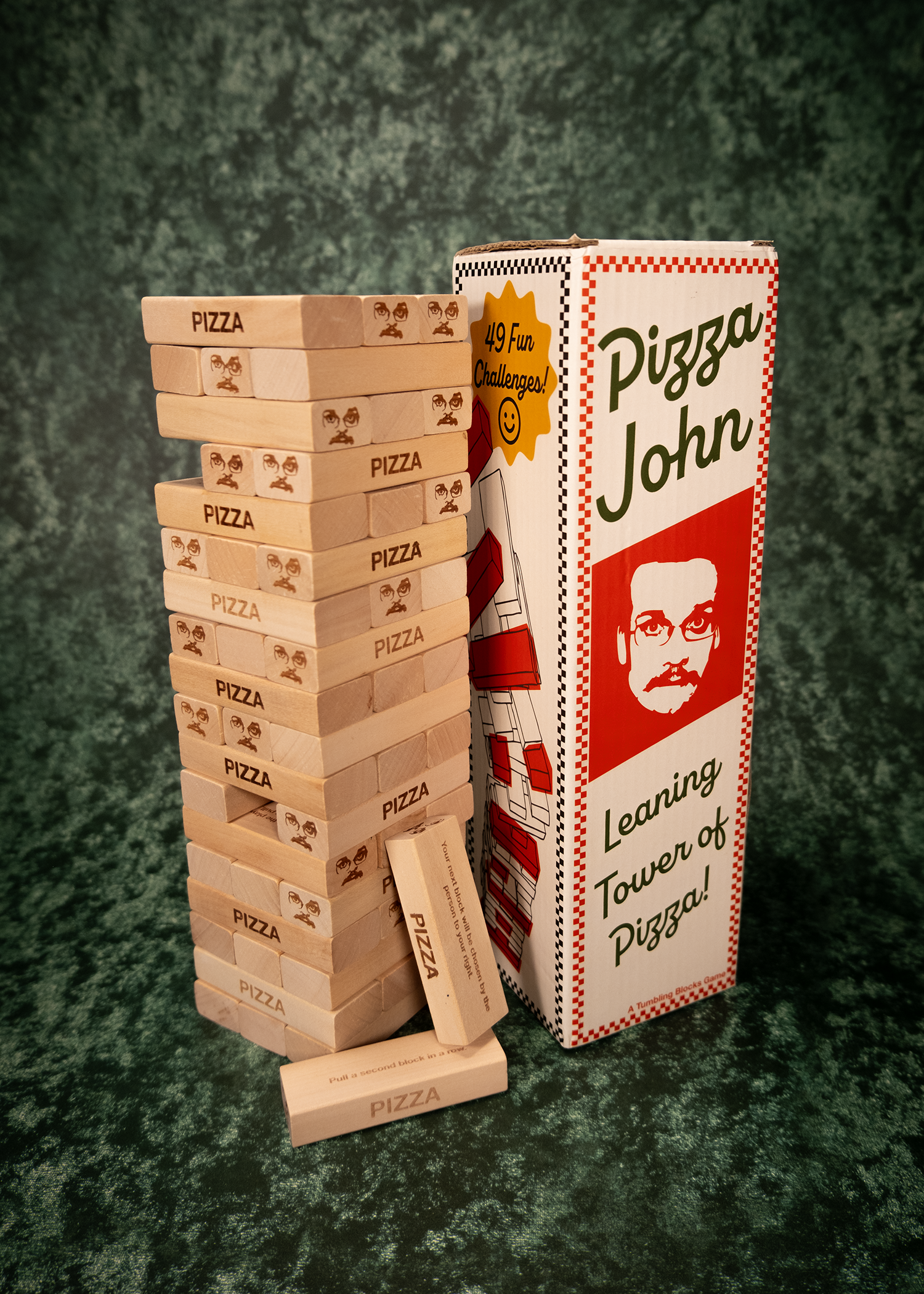 Leaning Tower of Pizza game with Pizza John packaging on a textured green background