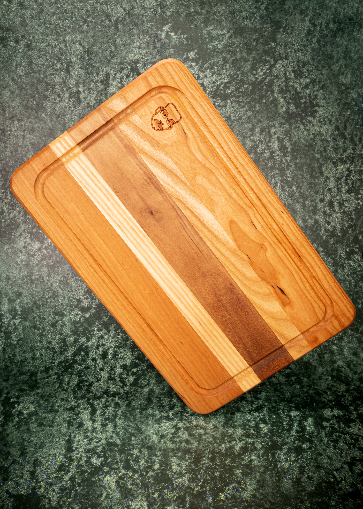 Wooden cutting board engraved with Pizza John on a textured surface