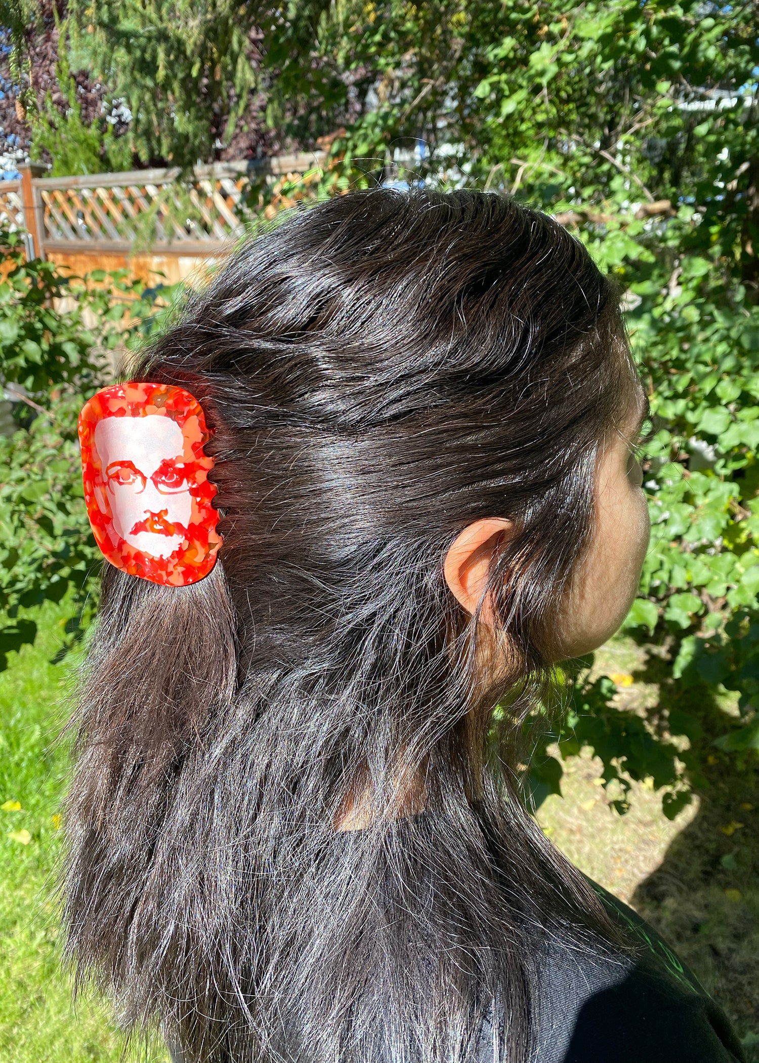 Person with a hair clip featuring a face design outdoors