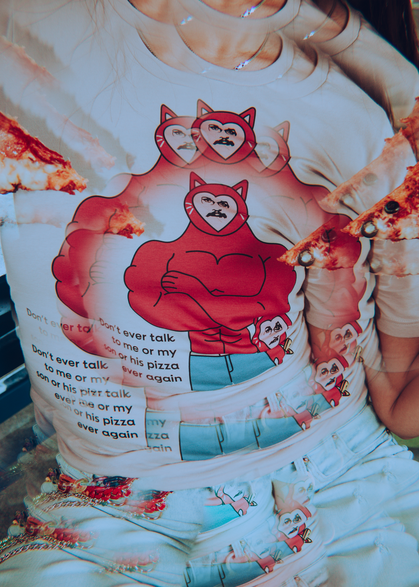 Person wearing t-shirt with a cartoon of a cat pizza john and text on a white background with a kaliedoscope filter